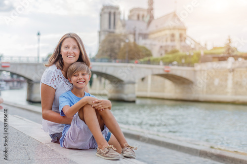 Happy mother and her son having fun near Notre-Dame cathedral in Paris. Tourists enjoying their vacation in France. © Max Topchii