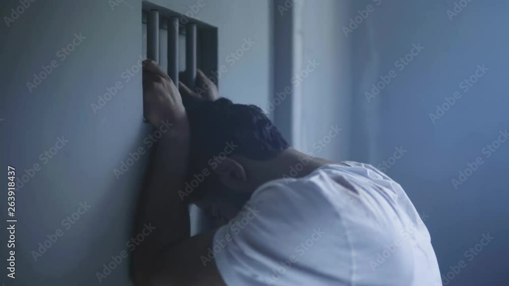 a depressed prisoner standing catching door of prison a depressed prisoner standing catching door of prison