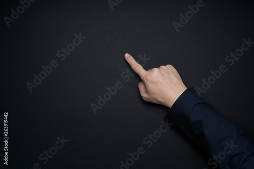Businessman hand pointing gesture pose isolated on black background . Flat lay and top view with copy space .