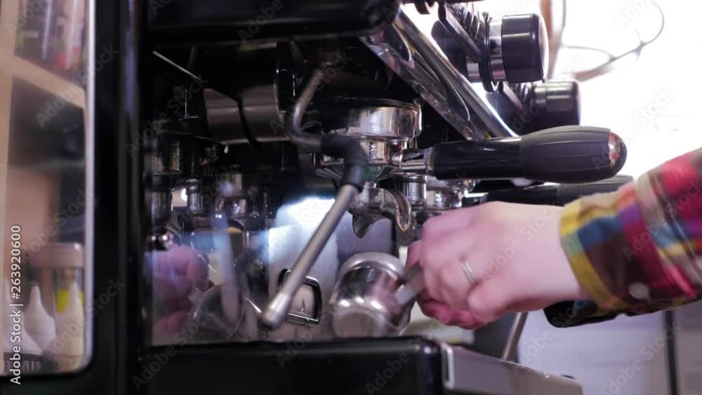 Close up barista is using a coffee maker machine in coffee shop Close up barista is using a coffee maker machine in coffee shop
