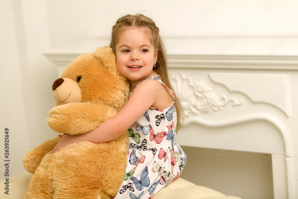 Little girl on sofa hugging teddy bear. Little girl on sofa hugging teddy bear.