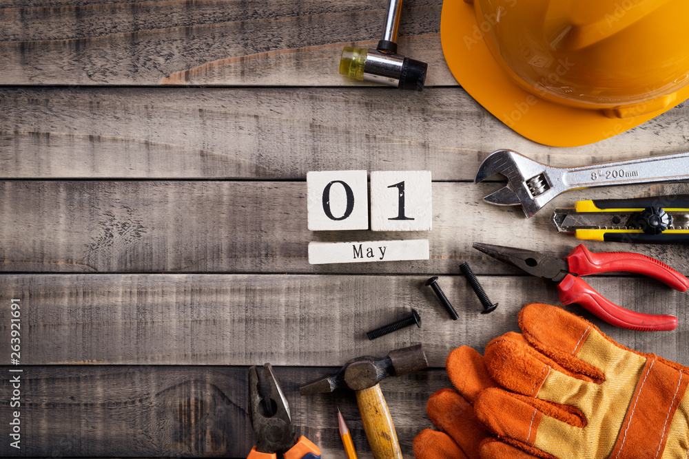 Labour Day, Wooden Block calendar with many handy tools on wooden background texture.