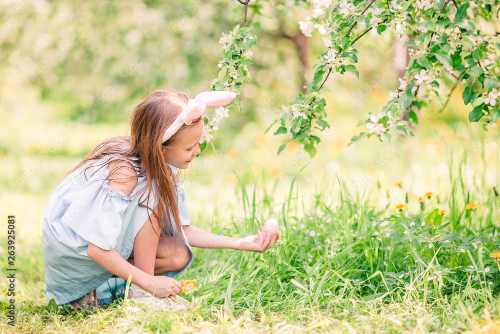 Adorable little girl in blooming apple garden on beautiful spring day Adorable little girl in blooming apple garden on beautiful spring day