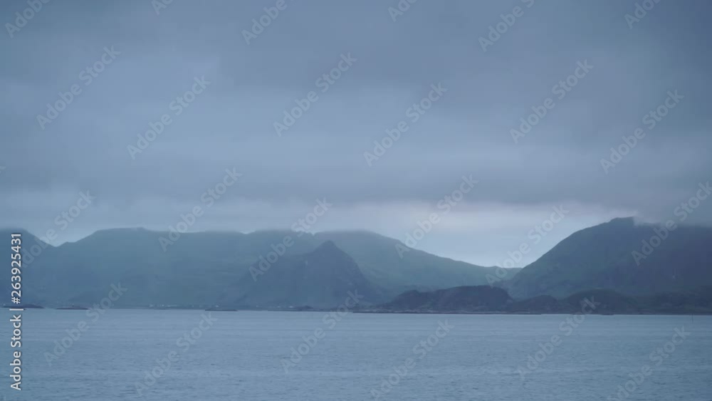 Sea landscape with mountains on horizon, Austvagoya island, Lofoten Norway. Hazy rainy cloudy day, overcast weather in summer. Sea landscape with mountains on horizon, Austvagoya island, Lofoten Norway. Hazy rainy cloudy day, overcast weather in summer.