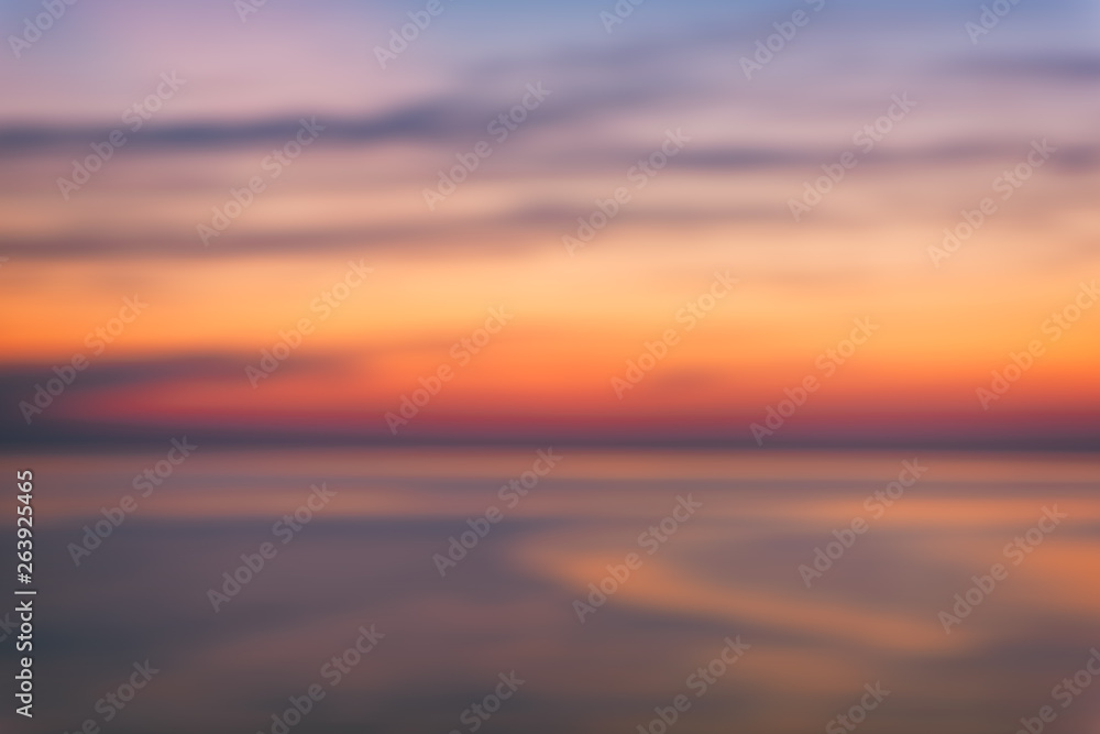 Blurred background of scenic sunset seascape with sea and amazing colorful cloudy sky, outdoor travel, motion blur