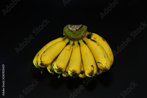 close up shot of bunch of banana with black dark background and have contrast shadow