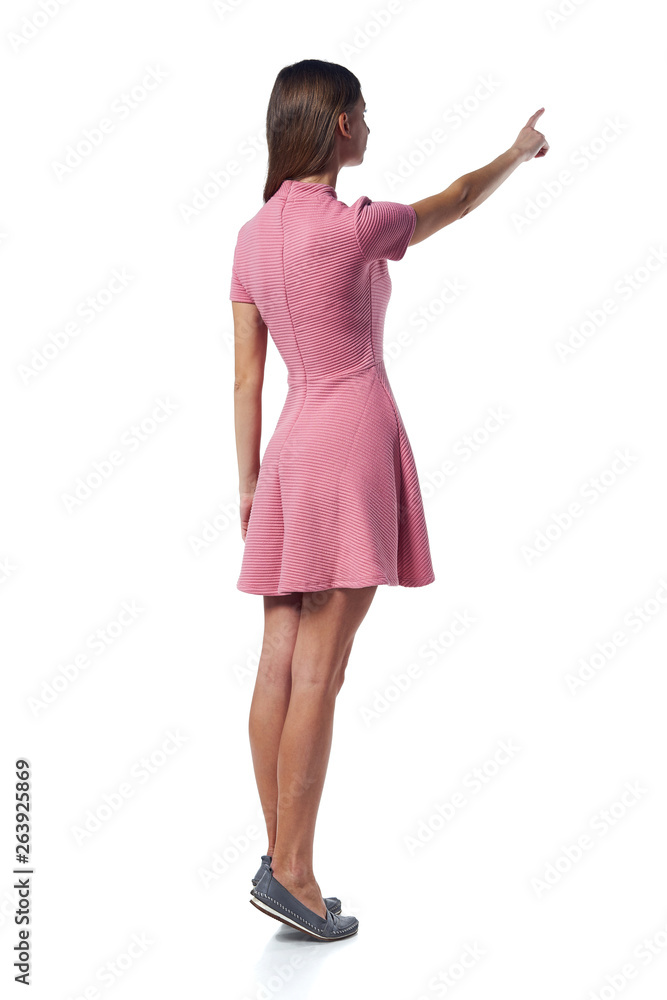 Full length woman in pink dress pointing to the side, back view Full length woman in pink dress pointing to the side, back view