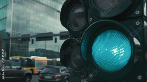 Slow Motion A typical traffic light at the Crossroads in the center of the capital of Germany, Berlin. The green light of the traffic light is on. In the background unrecognized buses and cars are