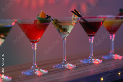 Different martini cocktails on table in bar, closeup