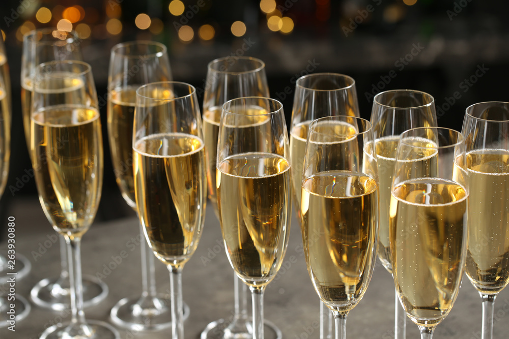 Glasses of champagne on table against blurred background Glasses of champagne on table against blurred background