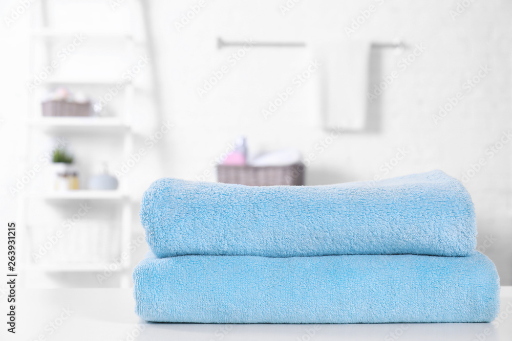 Stack of fresh towels on table in bathroom. Space for text Stack of fresh towels on table in bathroom. Space for text