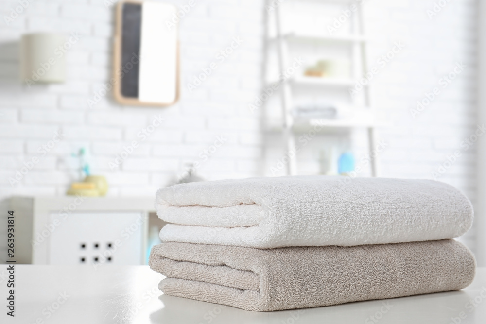 Stack of fresh towels on table in bathroom. Space for text Stack of fresh towels on table in bathroom. Space for text