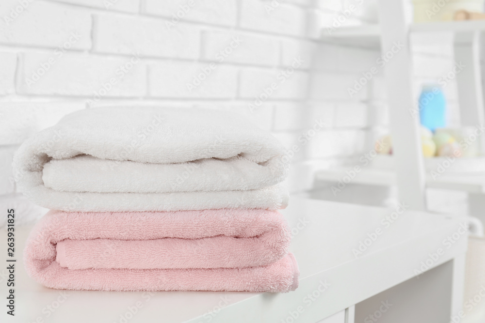 Stack of fresh towels on table in bathroom. Space for text Stack of fresh towels on table in bathroom. Space for text