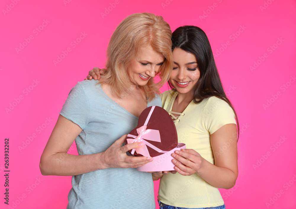 Young woman congratulating her mature mom on color background. Happy Mother's Day Young woman congratulating her mature mom on color background. Happy Mother's Day