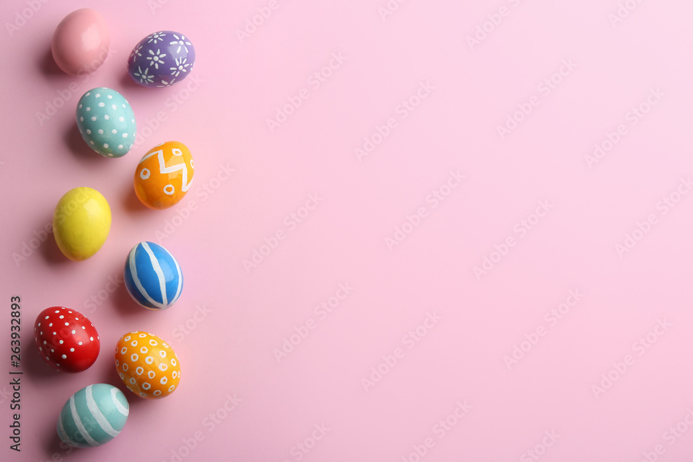 Flat lay composition of painted Easter eggs on color background, space for text