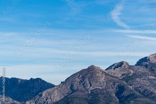 Montañas azules sobre cielo azul con nubes