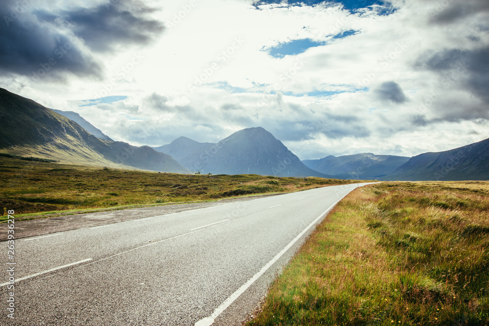 Trip or adventure: Abandoned, dramatic road in Scotland, cloudy sky. Trip or adventure: Abandoned, dramatic road in Scotland, cloudy sky.