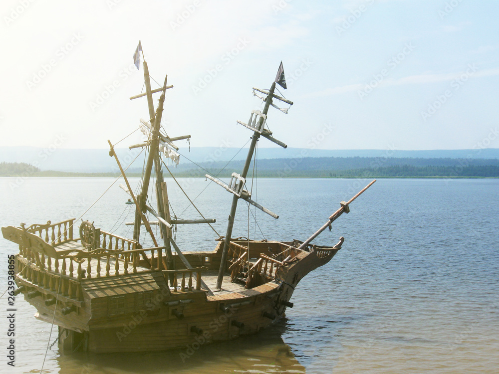 old wooden ship with mast anchored in the sun old wooden ship with mast anchored in the sun