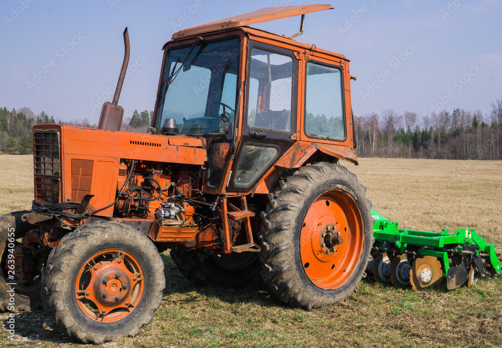 Old tractor for carrying out agricultural work in a field on a farm. Old tractor for carrying out agricultural work in a field on a farm.