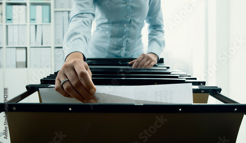 Tableau sur toile Office worker searching files in the archive