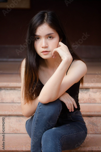 Portrait of thai china adult beautiful girl black shirt blue jeans relax and smile © tiniroma