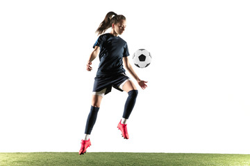 Female soccer player kicking ball isolated over white background