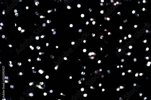 Abstract bokeh of white city lights on black background. defocused and blurred many round light
