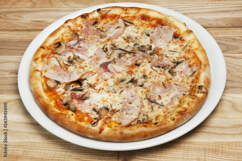 Delicious pizza with cheese, mushrooms and tomatoes on a wood background