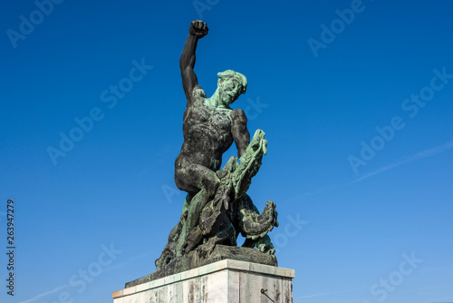 Hungary  Budapest  Gellert Hill  Dragon Slayer statue next to famous Liberty Statue or Freedom Statue above the city center of the Hungarian capital with blue sky in the background - travel liberation