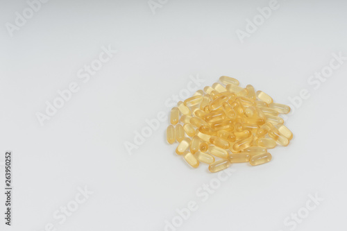 Yellow transparent capsules on a white background. Dietary supplements omega-3, omega-6 and omega-9. Vegan fish oil pills. photo