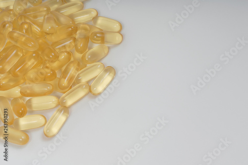 Yellow transparent capsules on a white background. Dietary supplements omega-3, omega-6 and omega-9. Vegan fish oil pills. photo