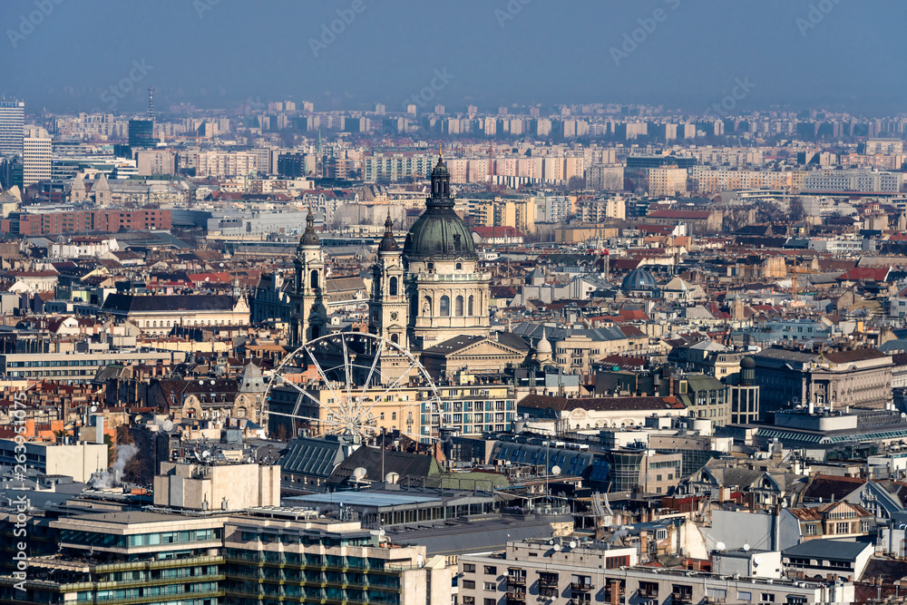 Obraz premium Hungary, Budapest: Skyline with St. Stephen's Basilica from above and mass of houses, buildings, apartments, rooftops in the city center of the Hungarian capital - concept urban travel.