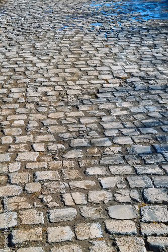Stone pavement texture. Granite cobble stoned pavement background.
