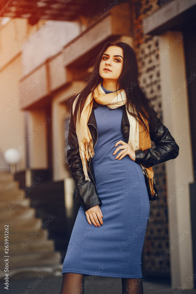 Fototapeta premium A stylish and beautiful girl standing in a summer city