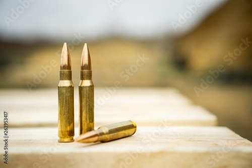 Tableau sur toile 308 caliber ammunition for a rifle standing on a wooden table on the background