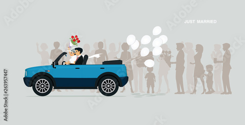 A newly married couple is on a car with a white balloon.