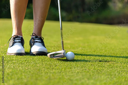 Sport Healthy. Close up Golfer asian sporty woman focus putting golf ball on the green golf on evening time. Healthy and Lifestyle Concept .