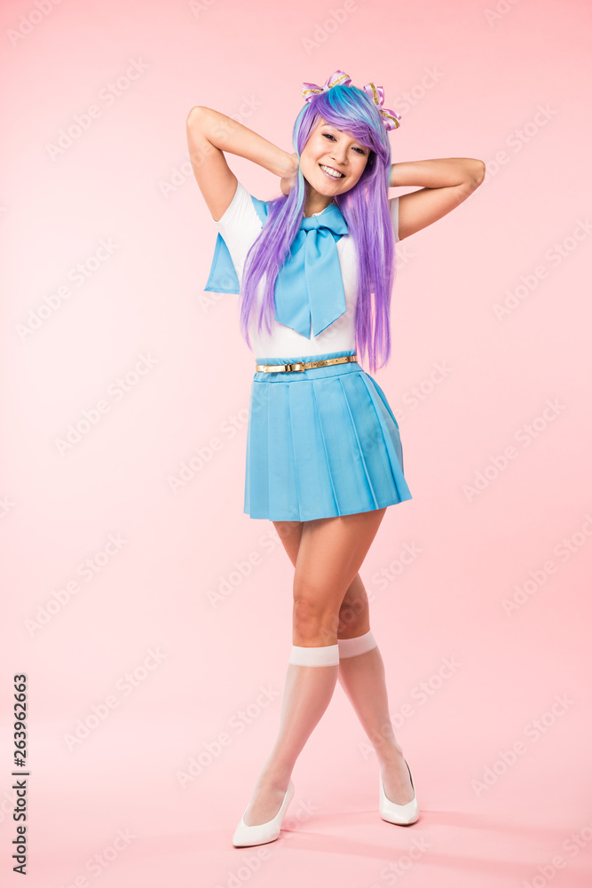 Full length view of otaku girl in purple wig smiling on pink Full length view of otaku girl in purple wig smiling on pink
