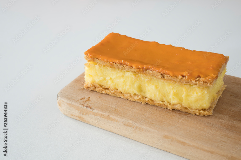 Orange tompouce, traditional Dutch treat with pudding and frosting on national holiday Kings Day (April 27th), in The Netherlands. White background, space for text Orange tompouce, traditional Dutch treat with pudding and frosting on national holiday Kings Day (April 27th), in The Netherlands. White background, space for text