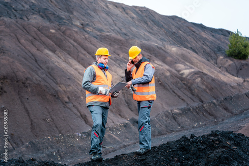 Workers in open-cast mining operation pit