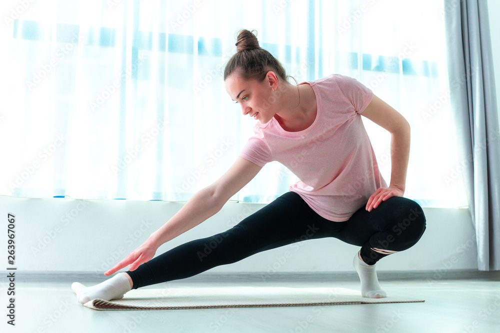 Young woman do stretching muscle and fitness exercises on yoga mat at home. Lose weight and keep fit. Healthy sports lifestyle Young woman do stretching muscle and fitness exercises on yoga mat at home. Lose weight and keep fit. Healthy sports lifestyle
