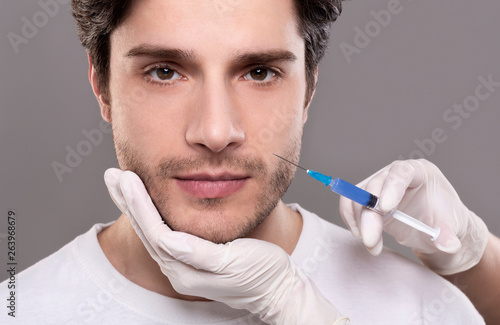 Plastic surgery concept. Man receiving injection in his face