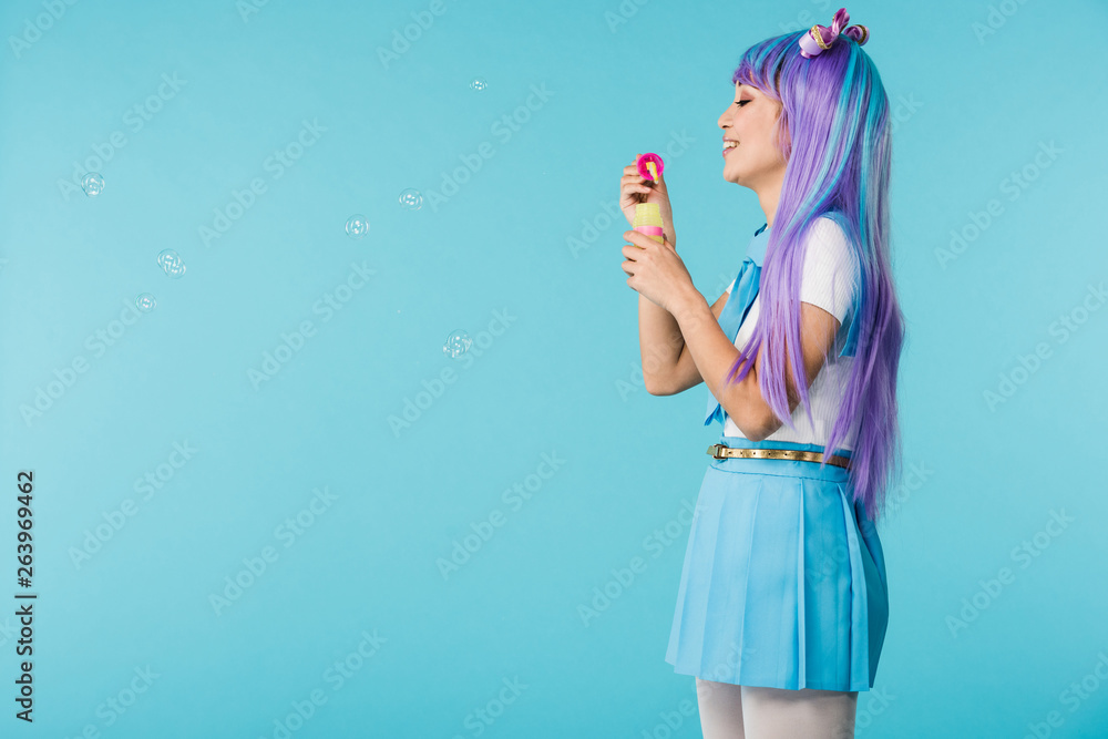  Vista lateral, de, anime, niña, con, pompas de jabón, aislado, en, azul Colección de foto