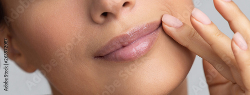 African-american girl holding hand near lips  grey background