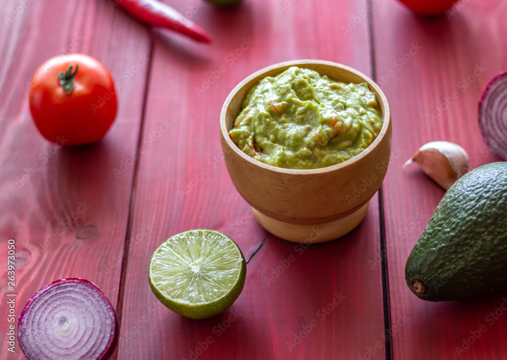 Guacamole and ingredients. Red background. Mexican cuisine. Guacamole and ingredients. Red background. Mexican cuisine.