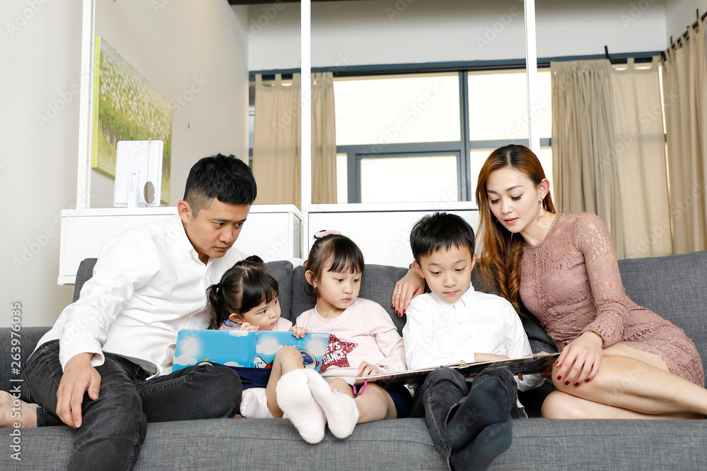 Parents Child Family father mother daughter son sit on sofa reading writing study teaching Parents Child Family father mother daughter son sit on sofa reading writing study teaching