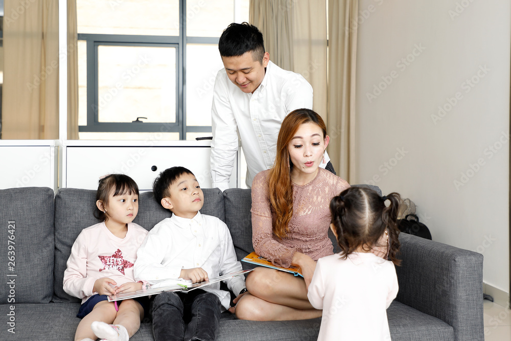 Parents Child Family father mother daughter son sit on sofa reading writing study teaching Parents Child Family father mother daughter son sit on sofa reading writing study teaching