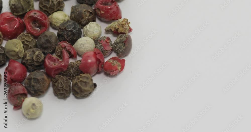 Mix of multicolored pepper rotation. Peas with spices. Macro on white background Mix of multicolored pepper rotation. Peas with spices. Macro on white background
