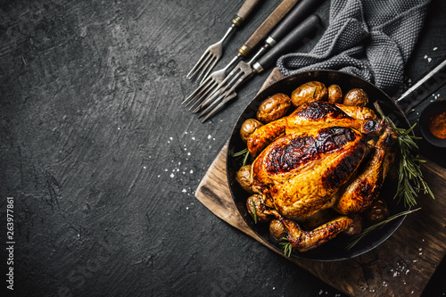 Baked whole chicken with spices on pan photo