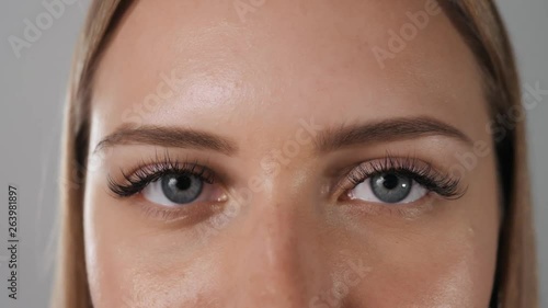 Female eye with long russian volume eyelashes close up blue eyes macro open nude clear skin